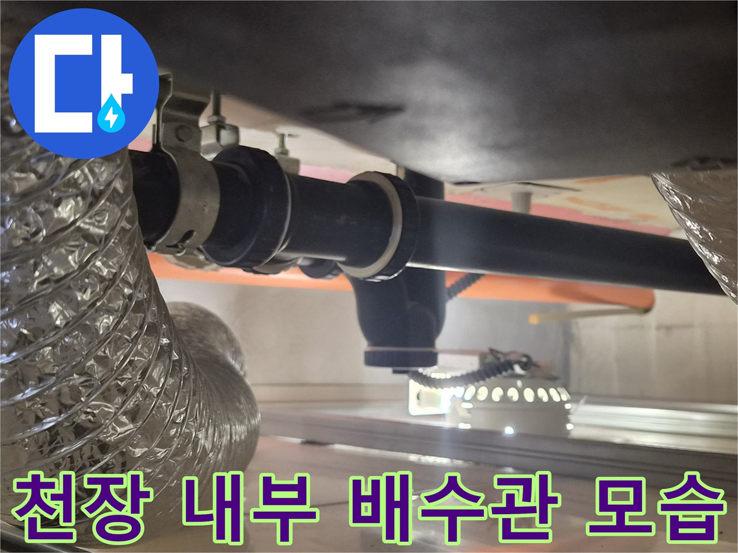 욕실 천장 구조물과 연결된 검은색 배수 배관 부속