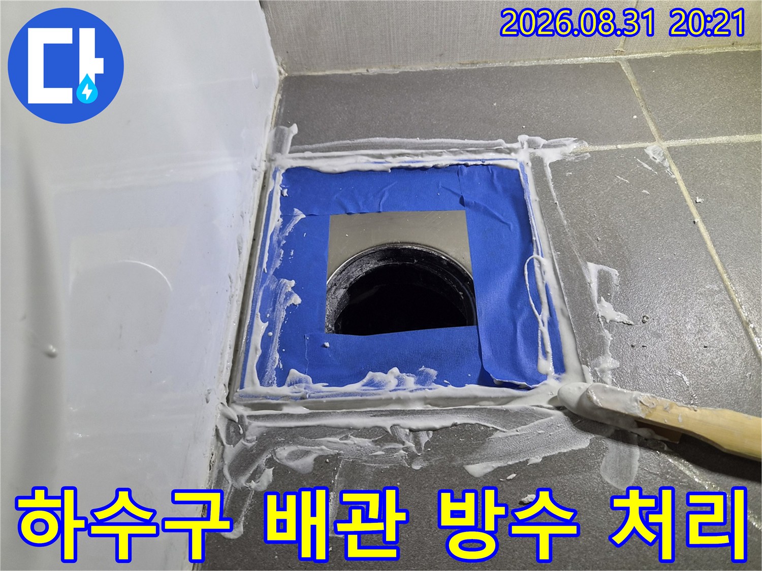 파란색 마스킹 테이프와 하얀색 방수재가 섞인 배관 작업 부위