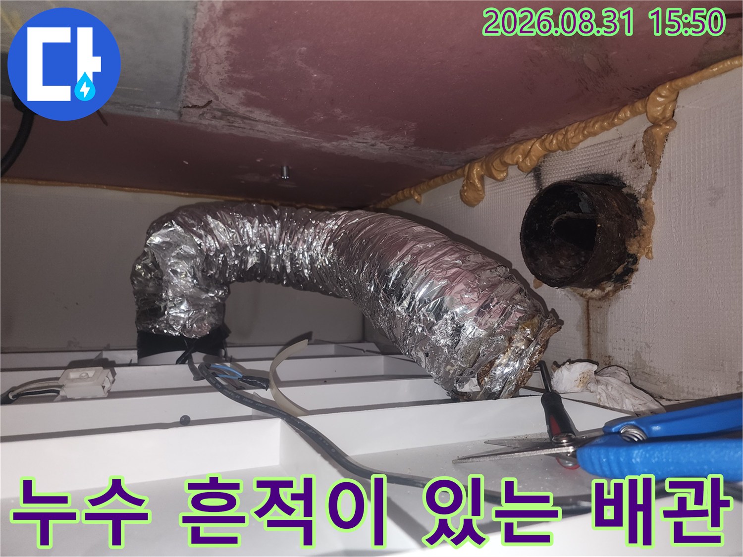 습기가 찬 은색 환기 덕트와 오염된 천장 내부 구조물