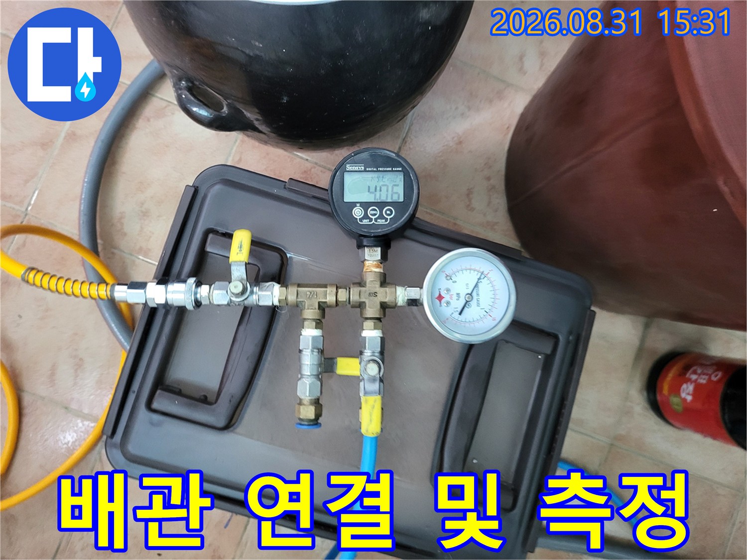 노란색 호스와 파란색 호스가 연결된 배관 압력 측정 장치 이미지입니다.