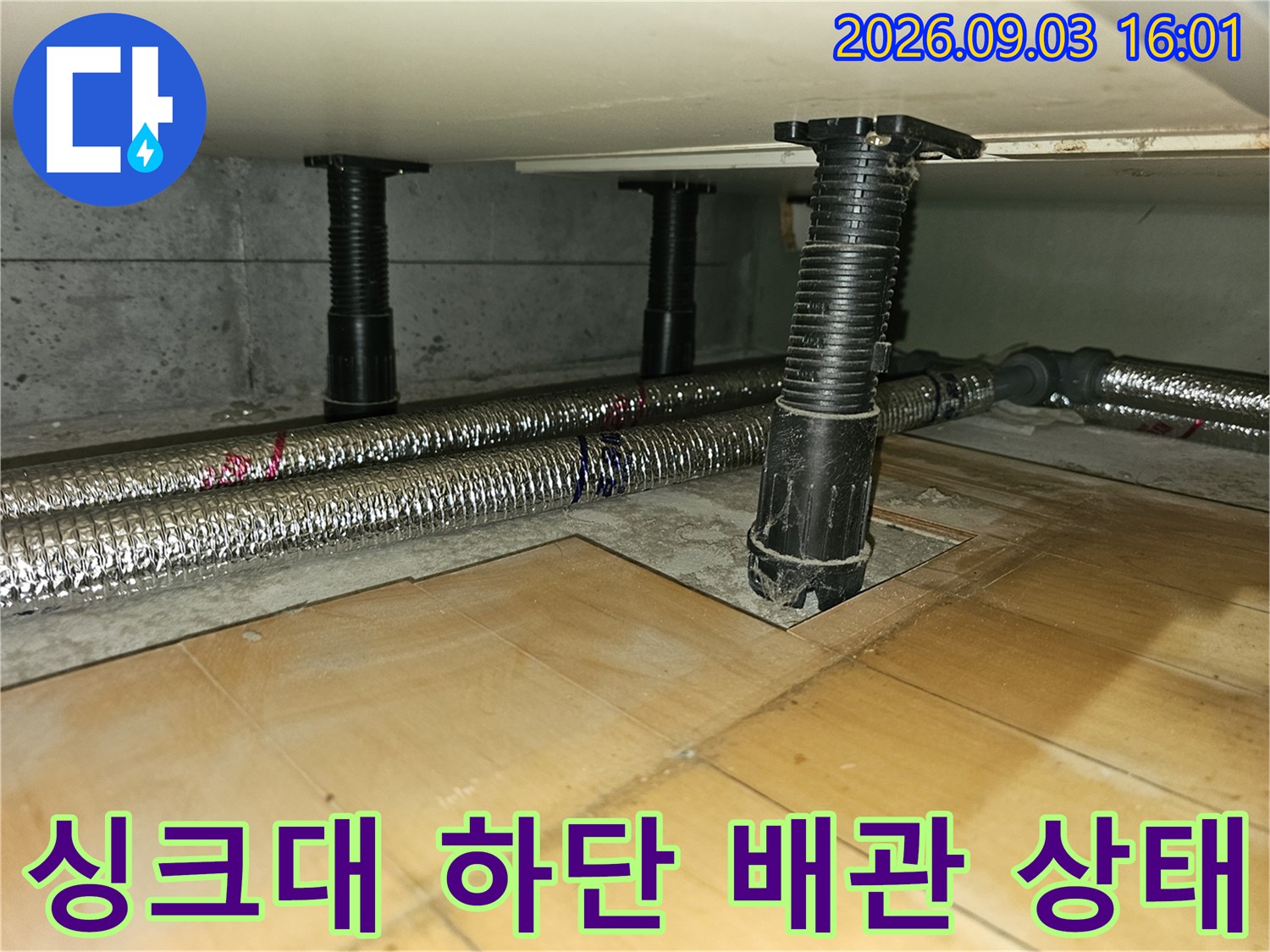 분당 백현동 아파트 싱크대 하단에 설치된 은색 보온재 배관과 검은색 지지대 모습