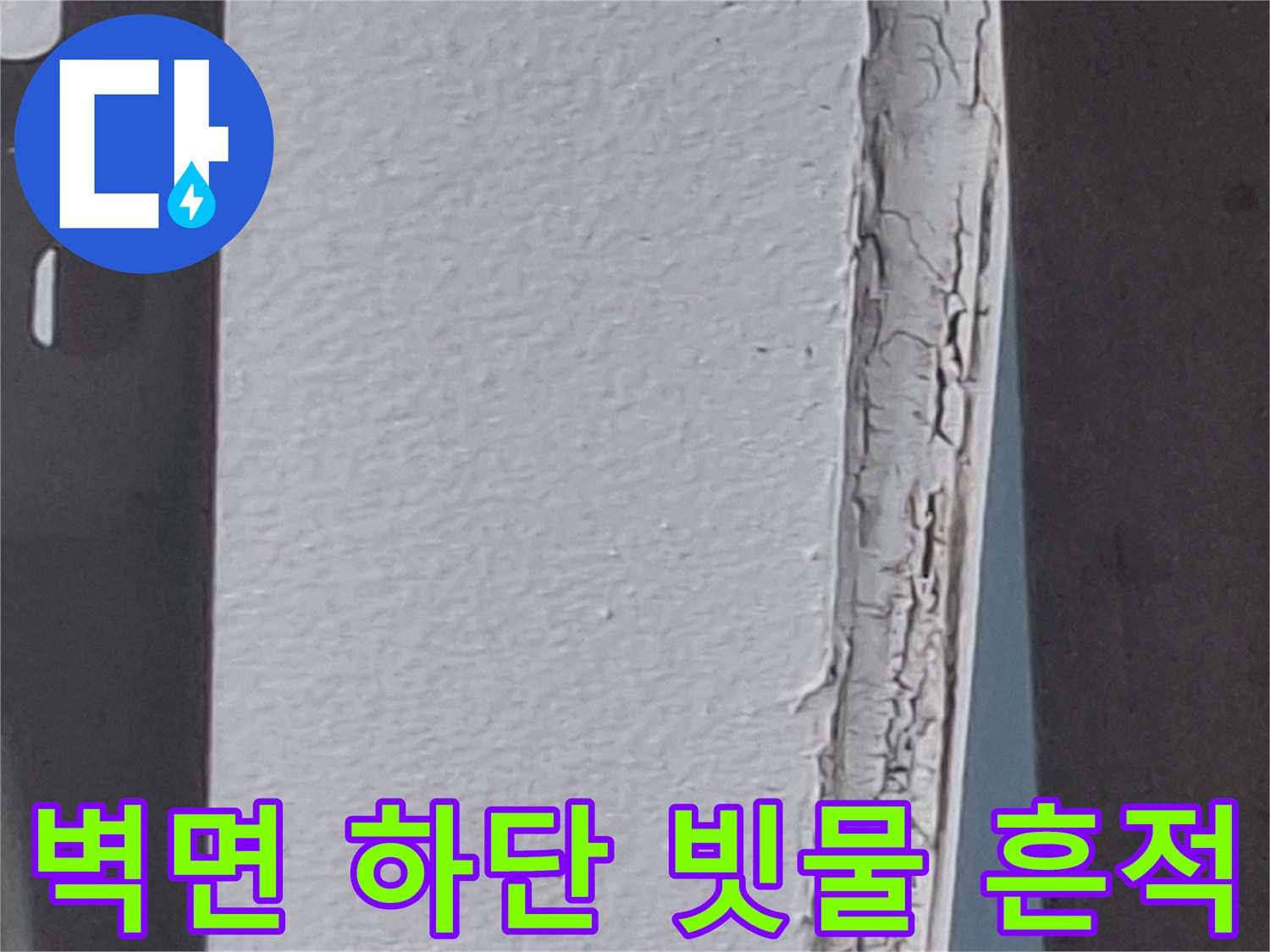 벽면 하단부의 젖은 얼룩과 갈라진 마감재 부위