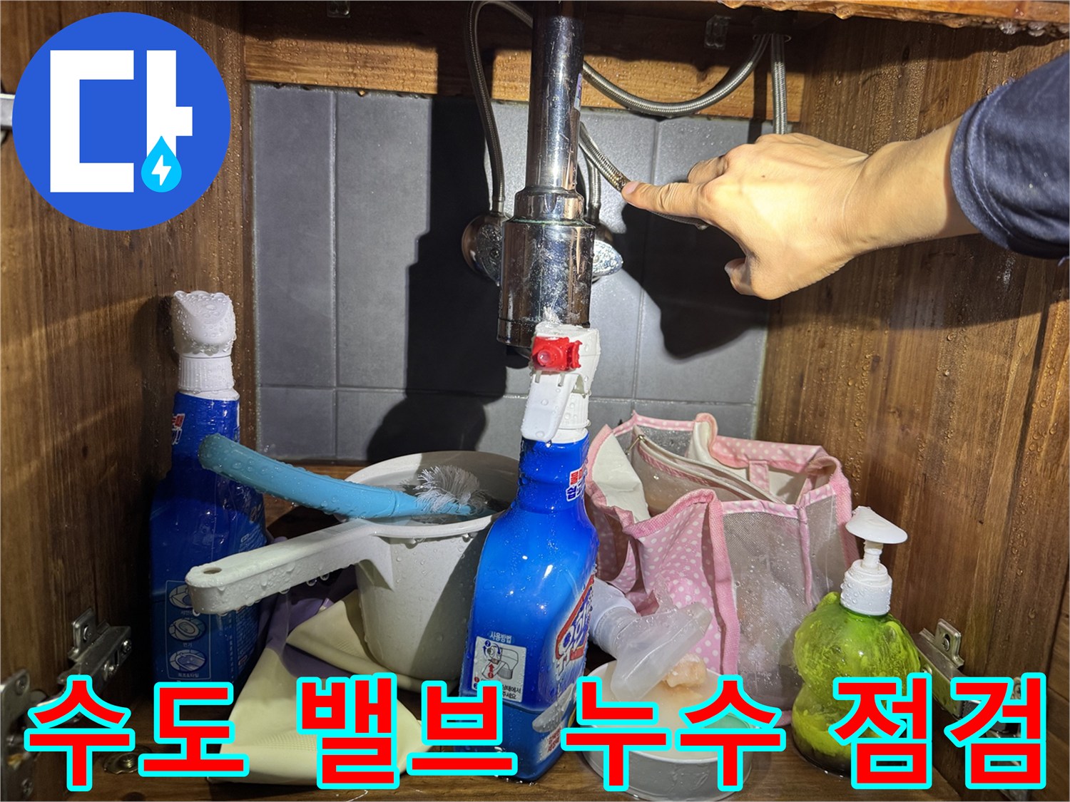세면대 아래쪽 앵글밸브 부근을 손으로 만지며 확인 중