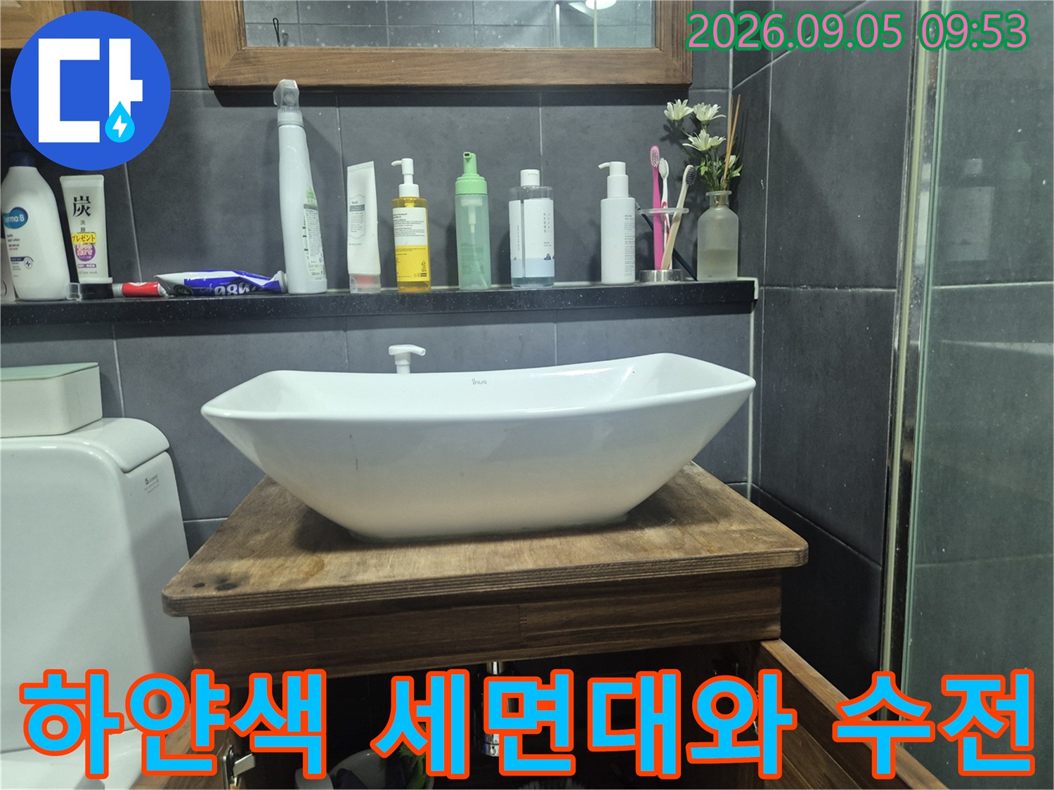 세면대 위에 설치된 하얀색 도기 세면대와 욕실 용품들