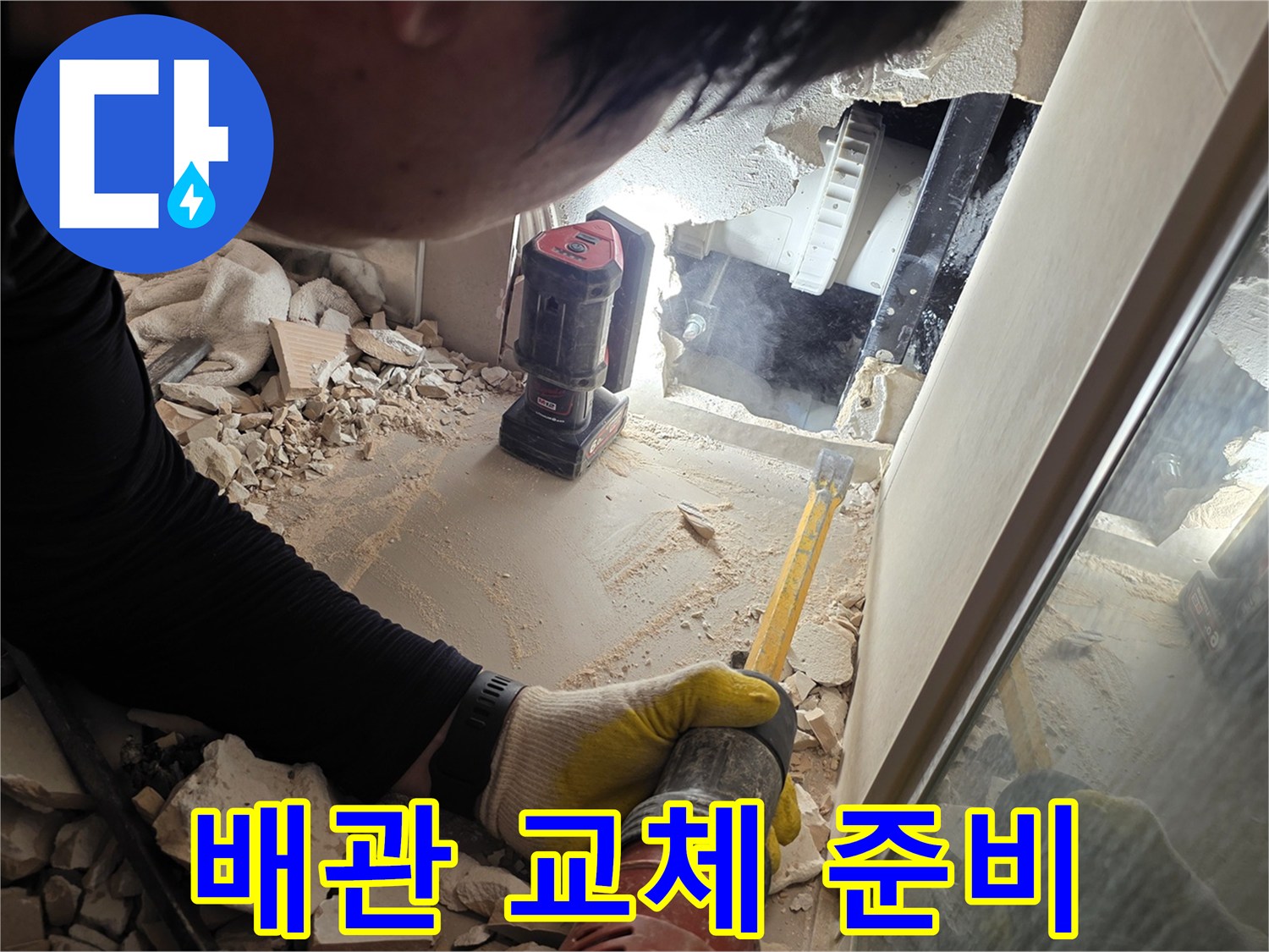 장비를 사용하여 배관 주변의 잔해를 정리하는 작업자 모습