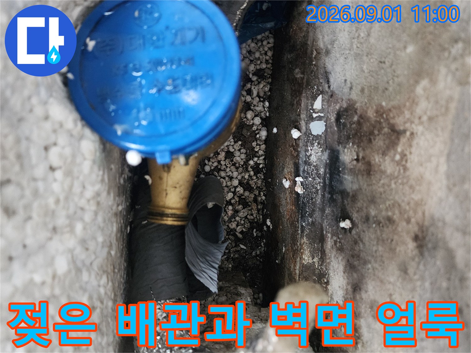 습기로 인해 젖어 있는 수도 배관 연결부와 콘크리트 벽면의 상태
