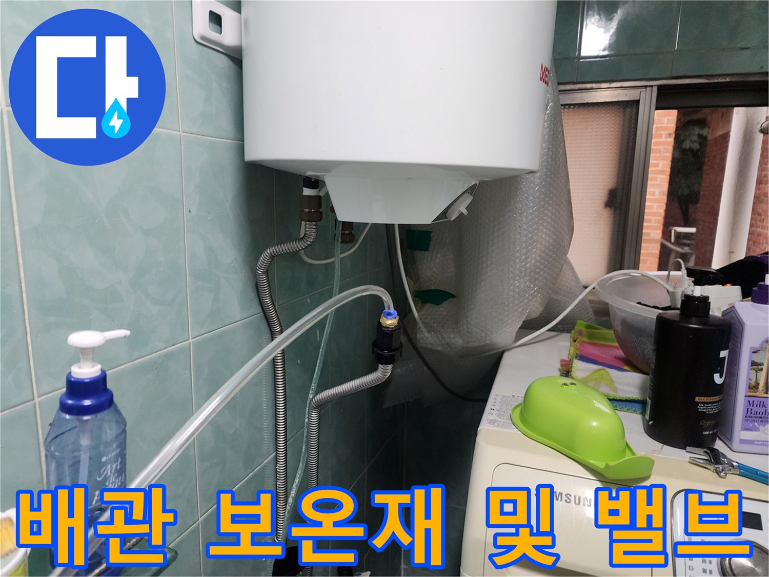 하얀색 탱크 아래 배관 연결 부위와 보온재가 설치된 모습입니다.