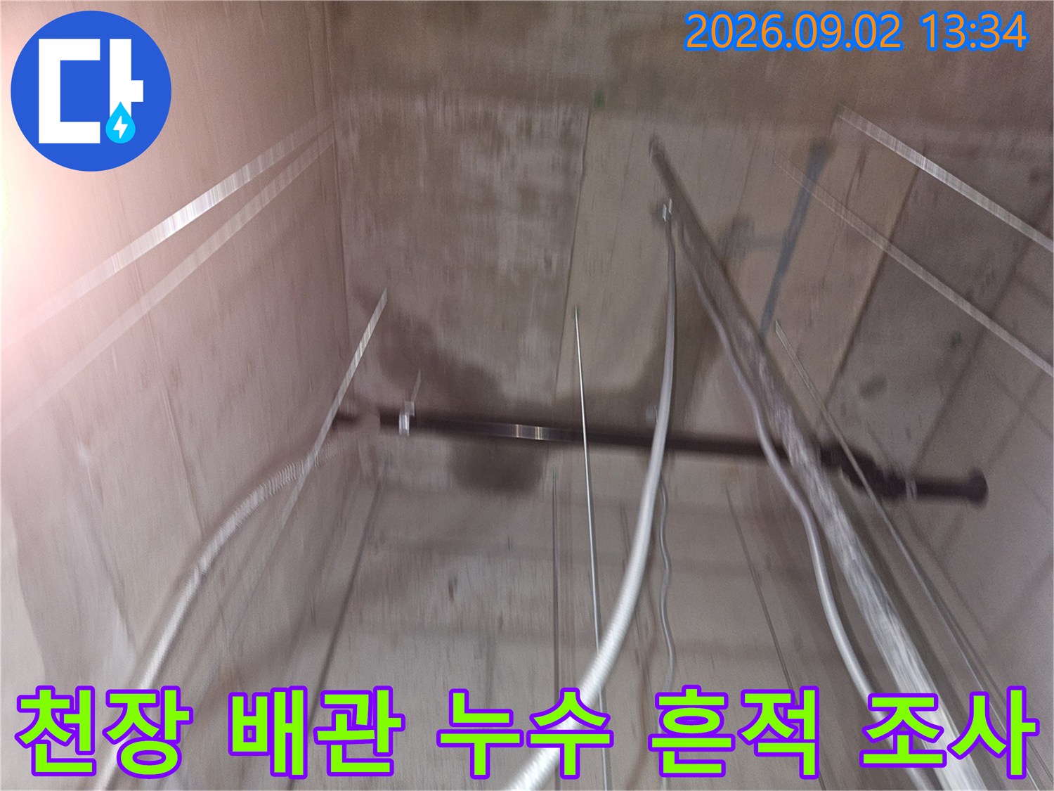 지하 창고 천장 콘크리트의 어두운 누수 얼룩과 배관 상태