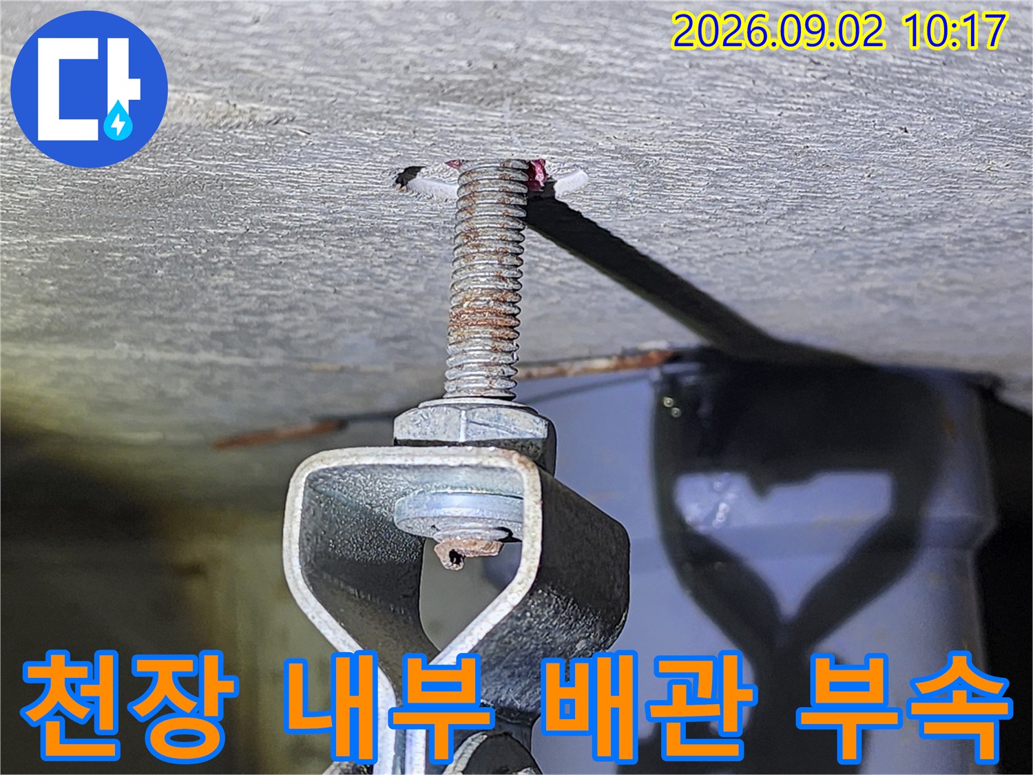 천장 구조물에 연결된 전산볼트와 금속 고정 장치입니다.