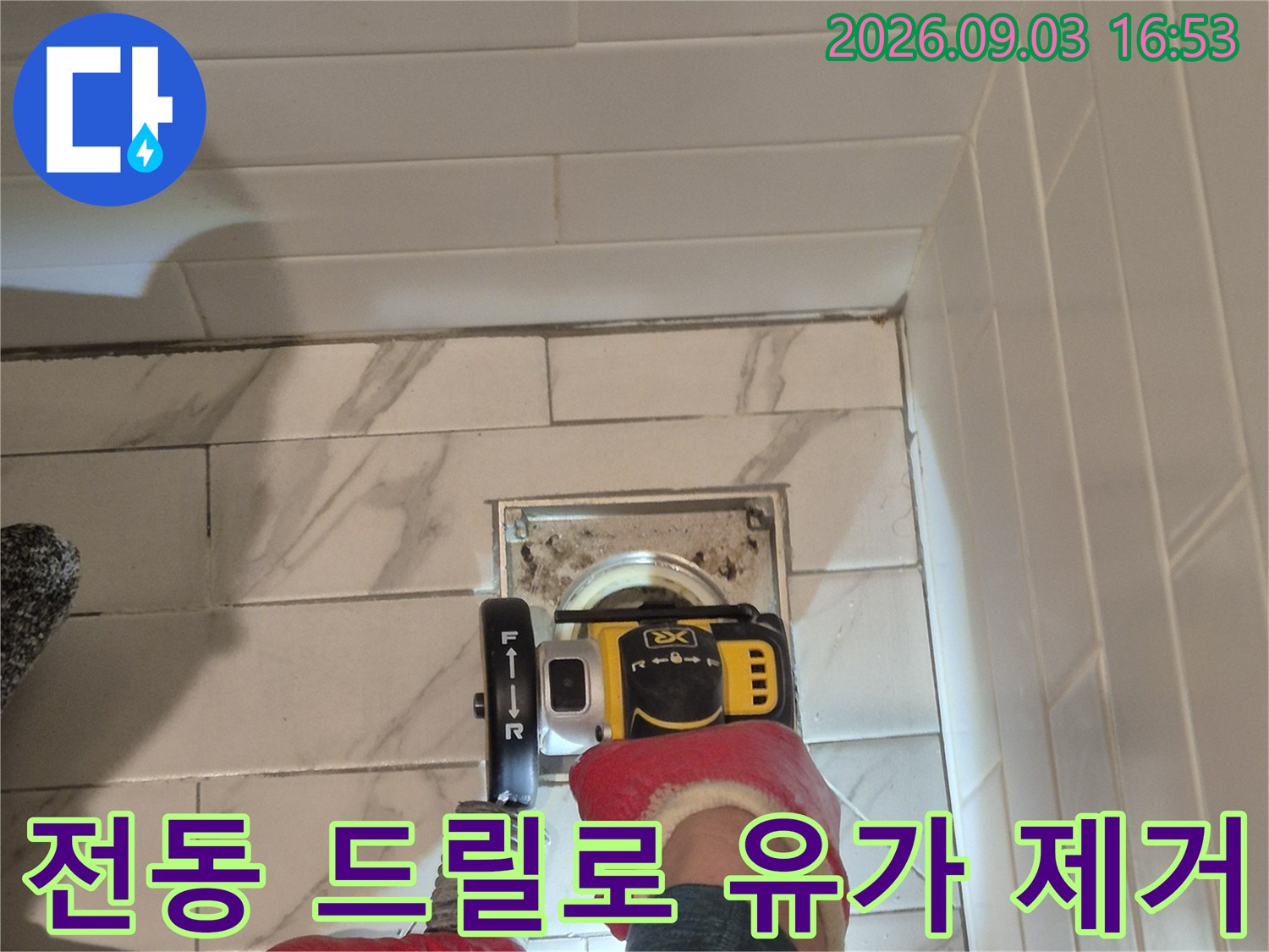 드릴 장비를 활용해 욕실 유가 마감재를 분리하고 있습니다.