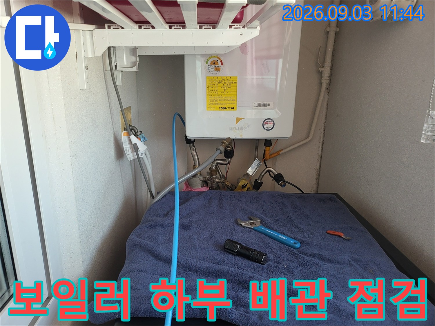 보일러 아래쪽 배관과 점검을 위해 준비된 렌치 및 조명기구