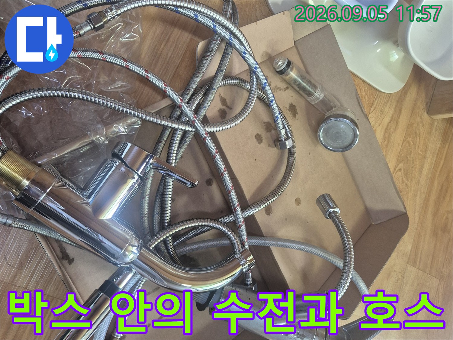 교체용으로 준비된 싱크대 수전 뭉치와 은색 연결 호스들