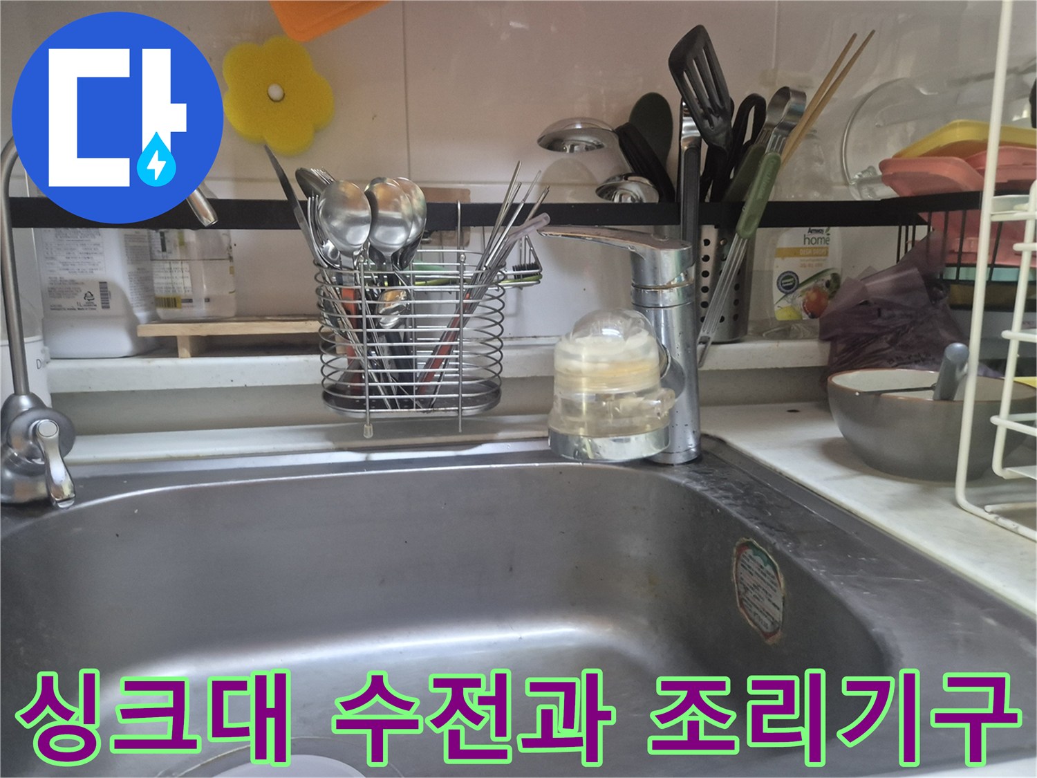 싱크대 수전 주변에 정리된 조리 도구와 세제통 모습입니다.
