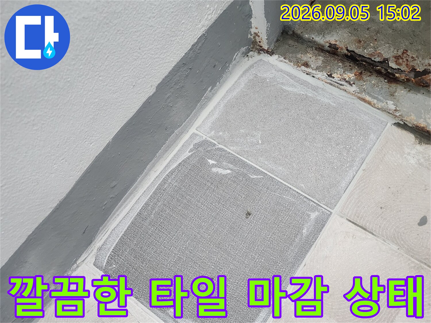 누수 수리 후 미장과 타일로 복구된 벽면 경계 부분