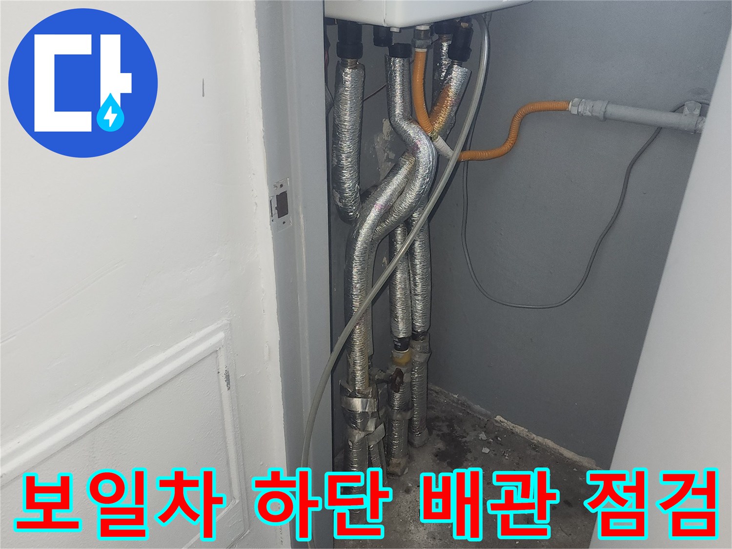 보일러 본체 아래로 뻗어 나온 은색 주름관과 호스들
