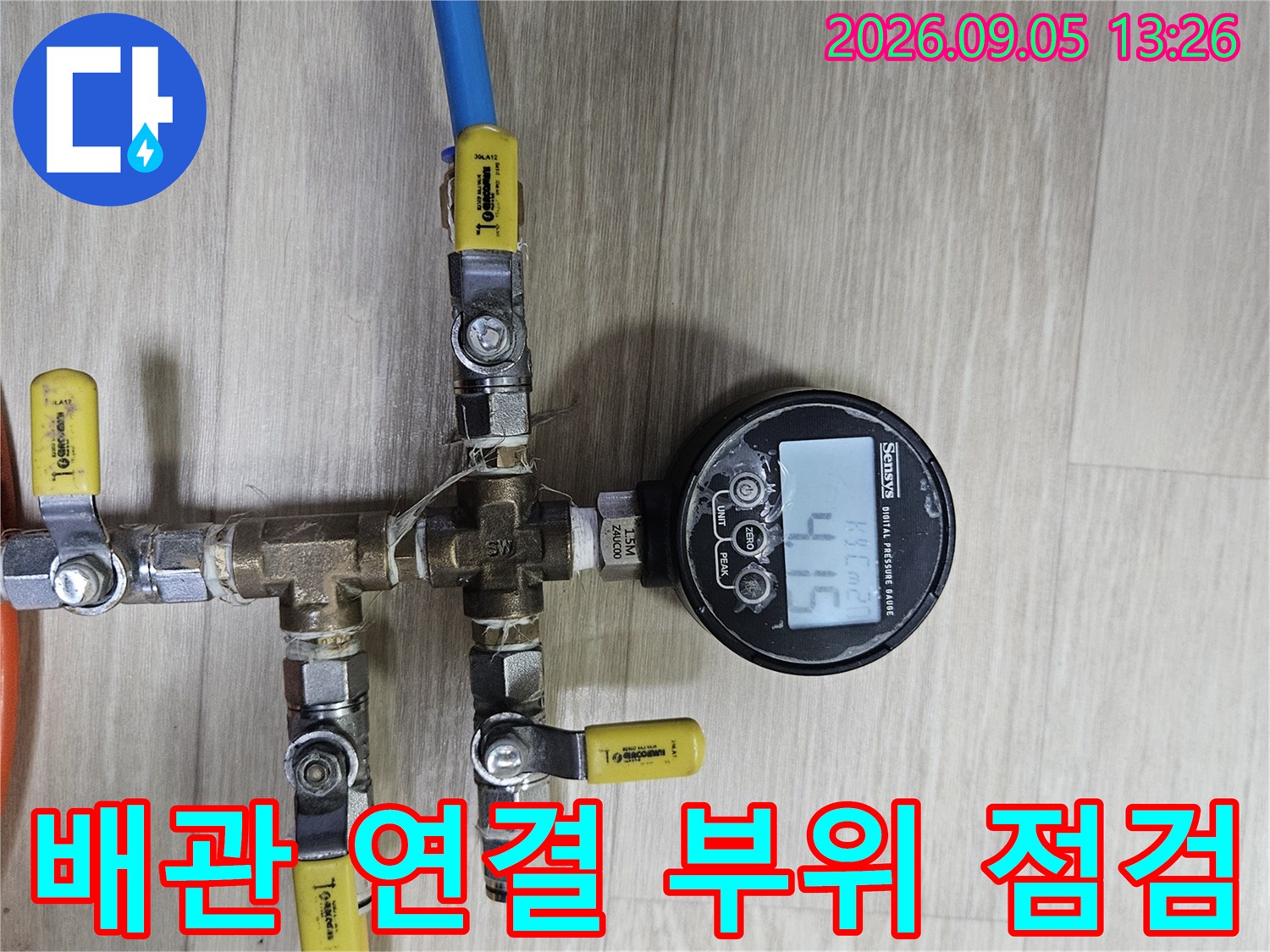 노란색과-파란색-배관이-연결된-부속품에-압력계를-설치한-모습