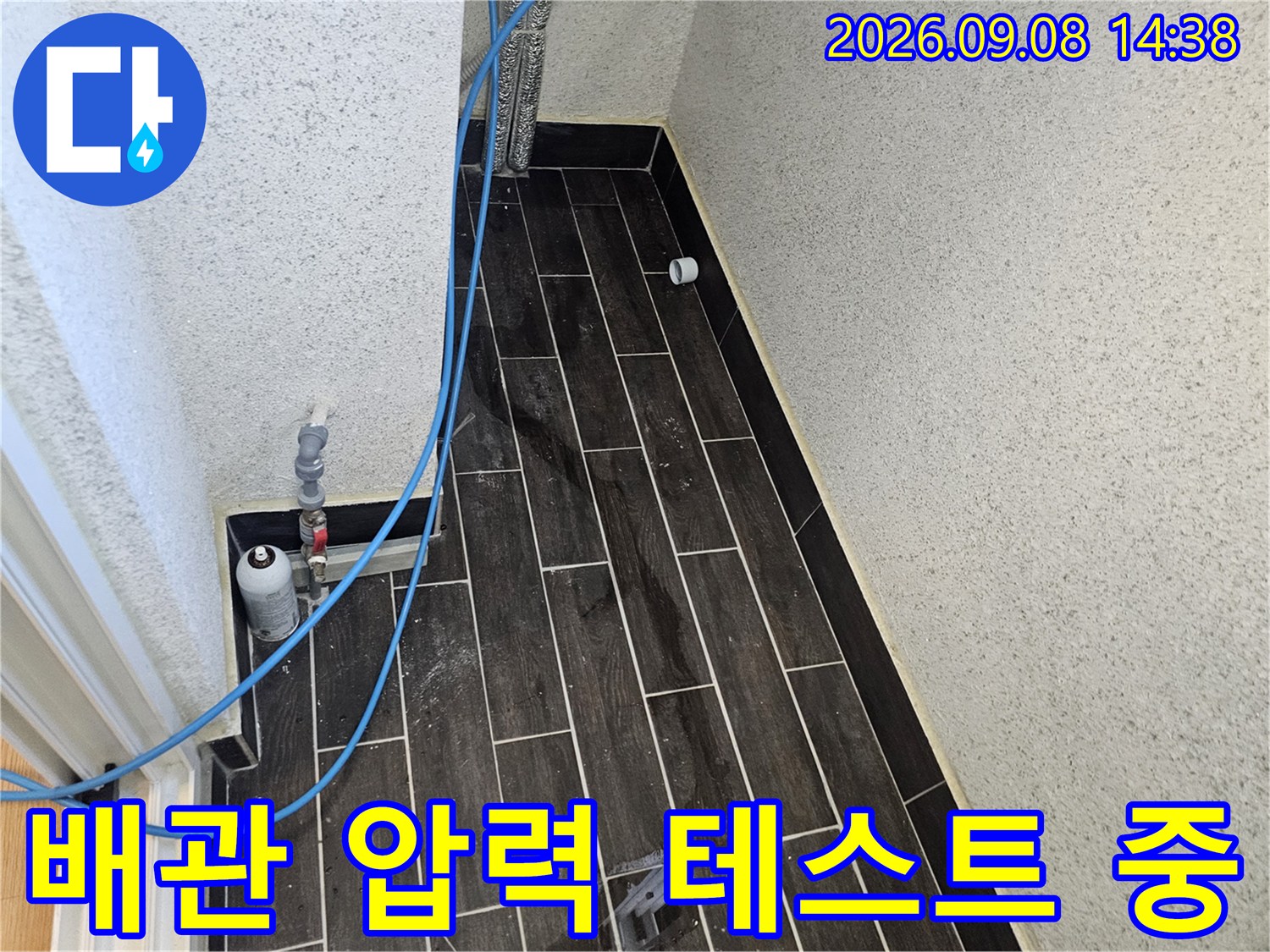 파란색 호스가 연결된-배관 압력 검사 장비의-근접 촬영 사진입니다.