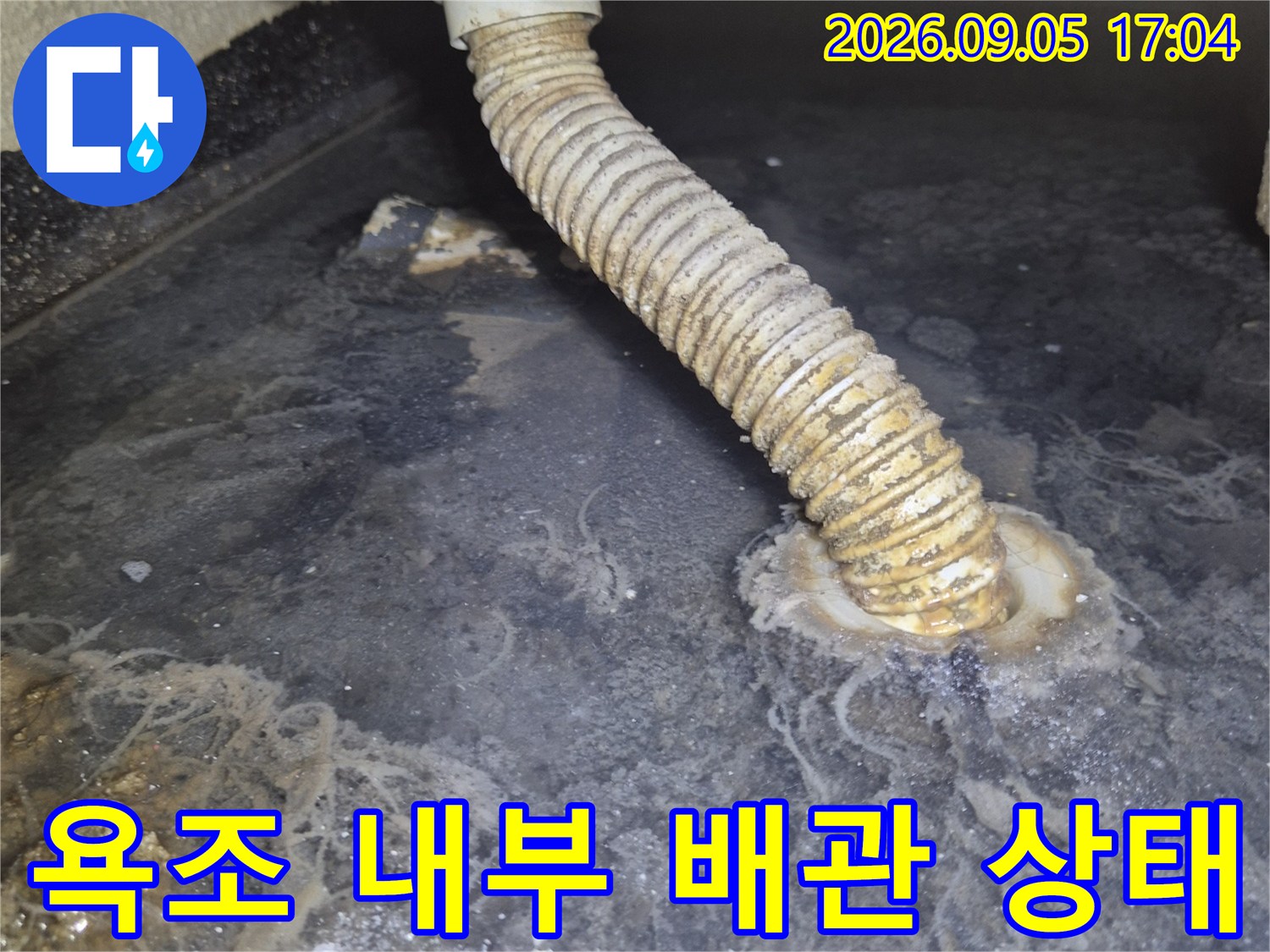 욕조 측면 점검구 안쪽의 노후된 배관 및 파손 부위