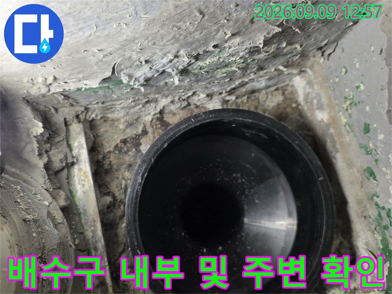 검은색 배수관과-주변의 거친 시멘트 마감 상태