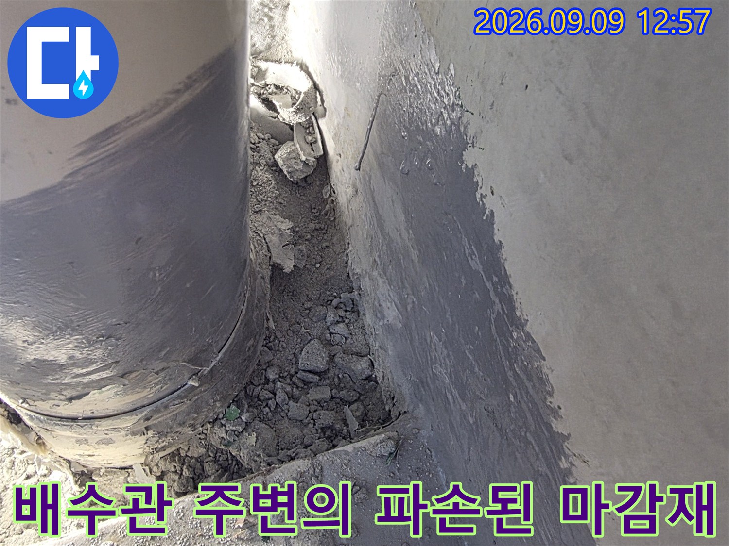 배수관 주변에 흩어진 시멘트 조각과 노후된 배관 상태