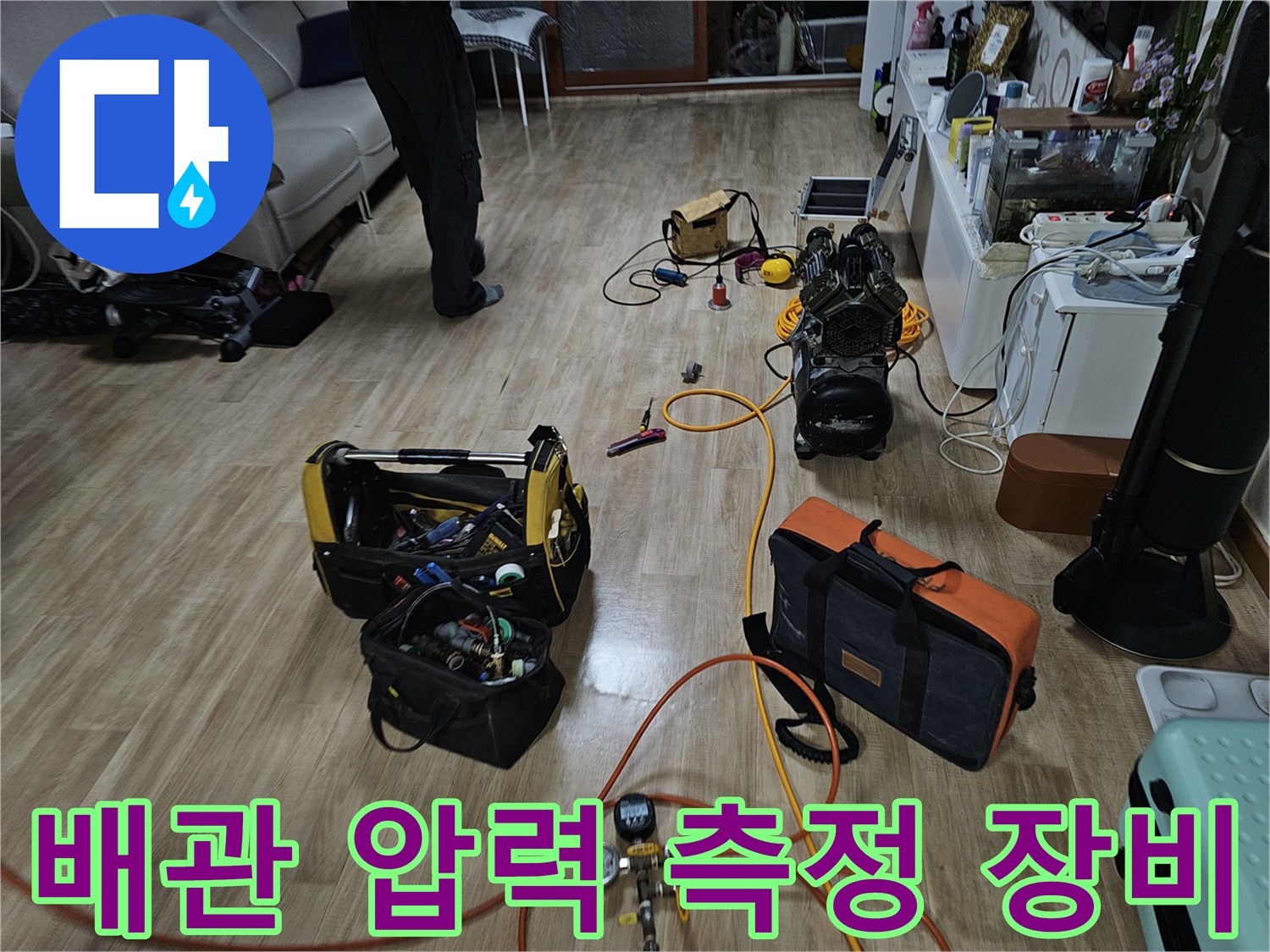누수 진단을 위해 거실 바닥에 설치된 배관 압력 테스트 장비와 각종 공구들입니다.