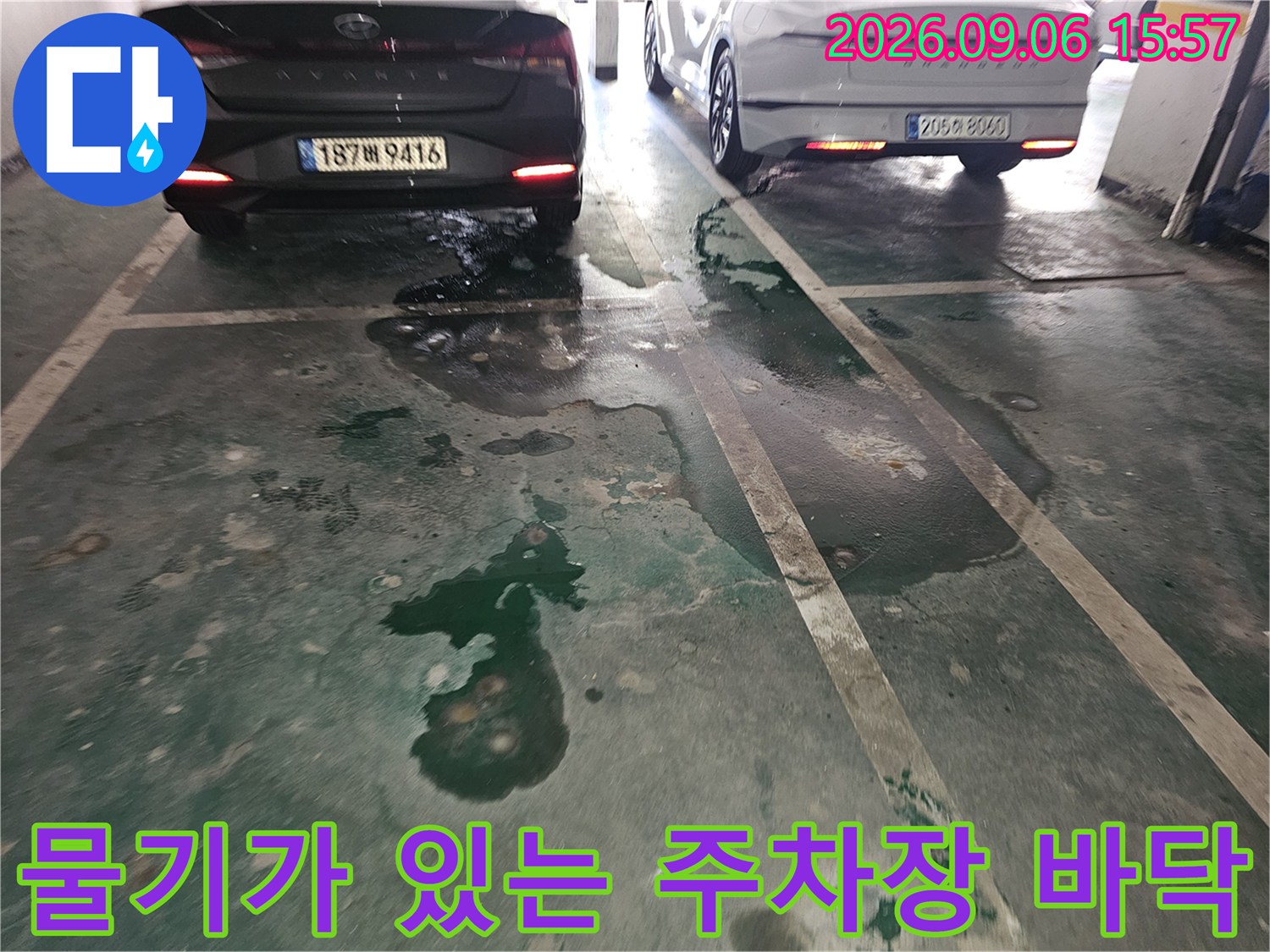 주차된 차량 아래쪽으로 번진 누수 물기와 바닥 얼룩