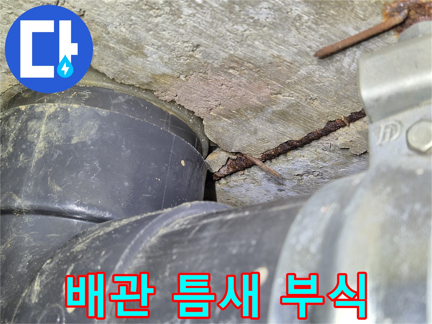 검은-배관-옆의-갈라진-시멘트와-녹슨-금속-잔해