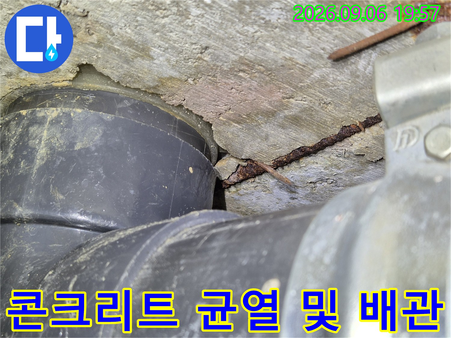 오수관 주변 콘크리트 층에 발생한 균열과 습기 흔적을 나타냅니다.