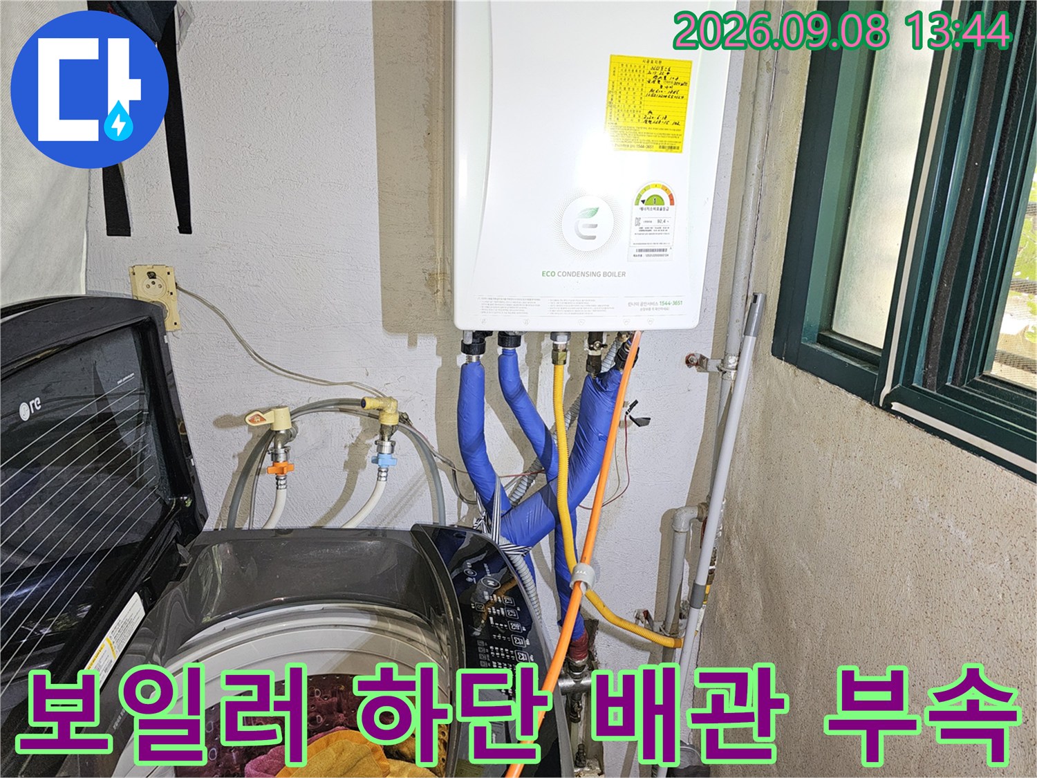 흰색 보일러 아래 파란색 온수 배관과 연결된 부속품들입니다.