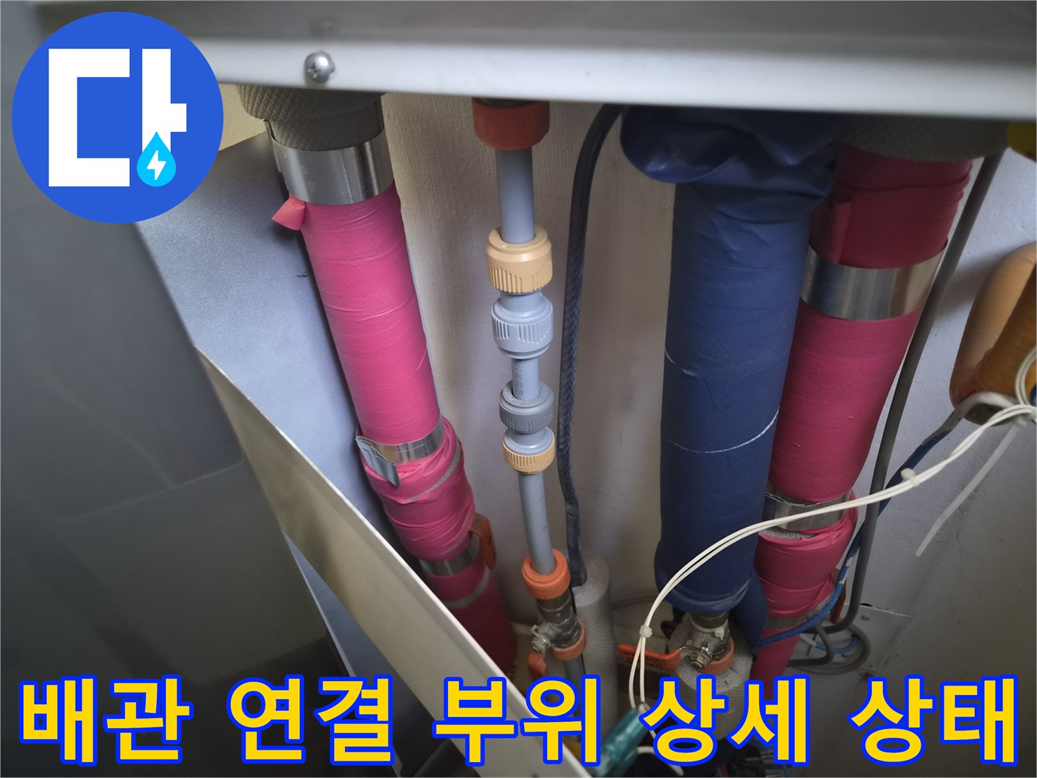 분홍색과 파란색 관이 겹쳐진 배관실 내부 모습