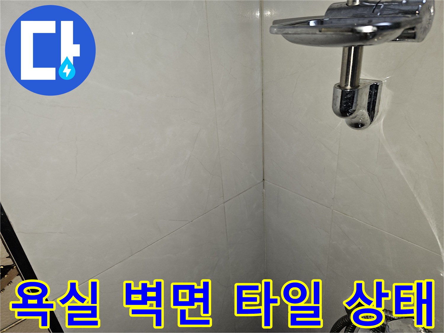 깨끗하게 시공된 화장실 벽면 타일과 샤워기 거치대 부위