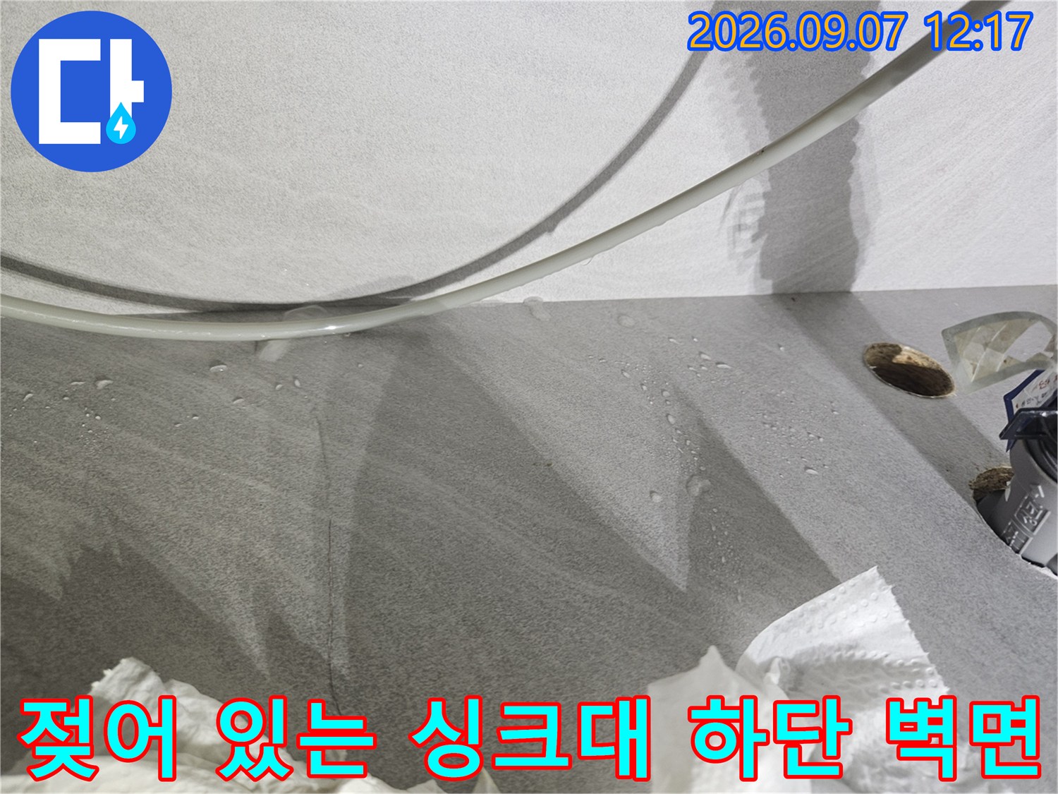 누수로 인해 물기가 맺히고 젖어버린 싱크대 하부 벽면 모습입니다.
