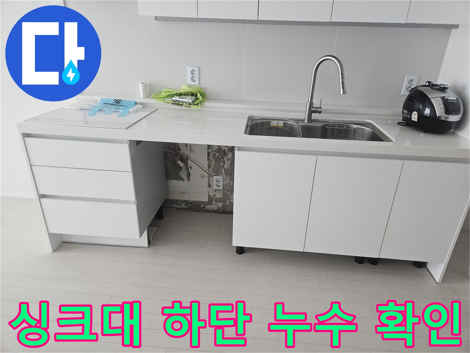 싱크대 하부장의 젖어 있는 배관과 호스 연결 부위 모습
