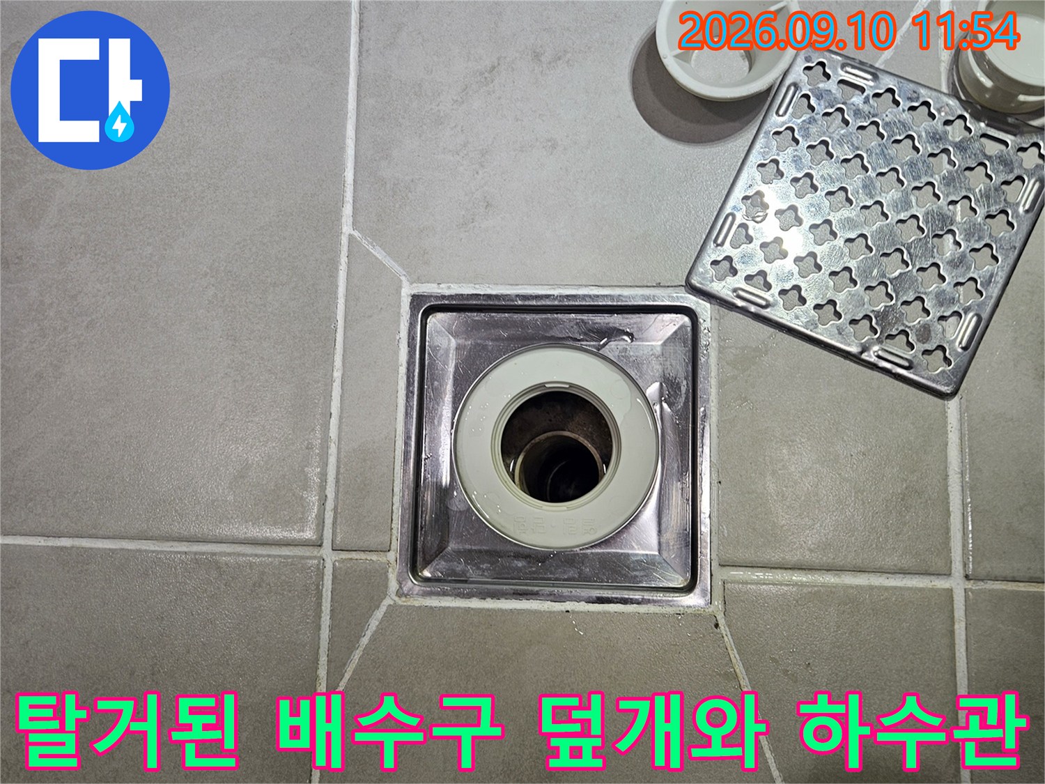 분리된 유가 덮개 옆에 보이는 화장실 바닥 배수구 입구 모습