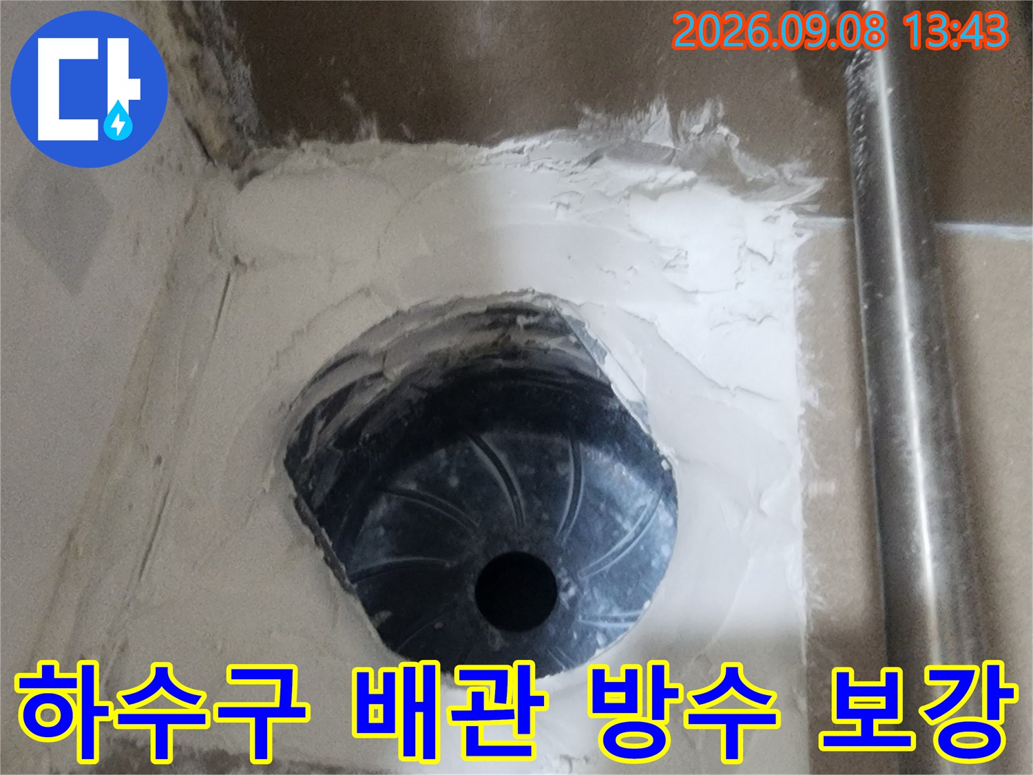 하수구-배관 입구 주변에 하얀색 방수재를 넓게 펴 발라 수밀성을 높였습니다.
