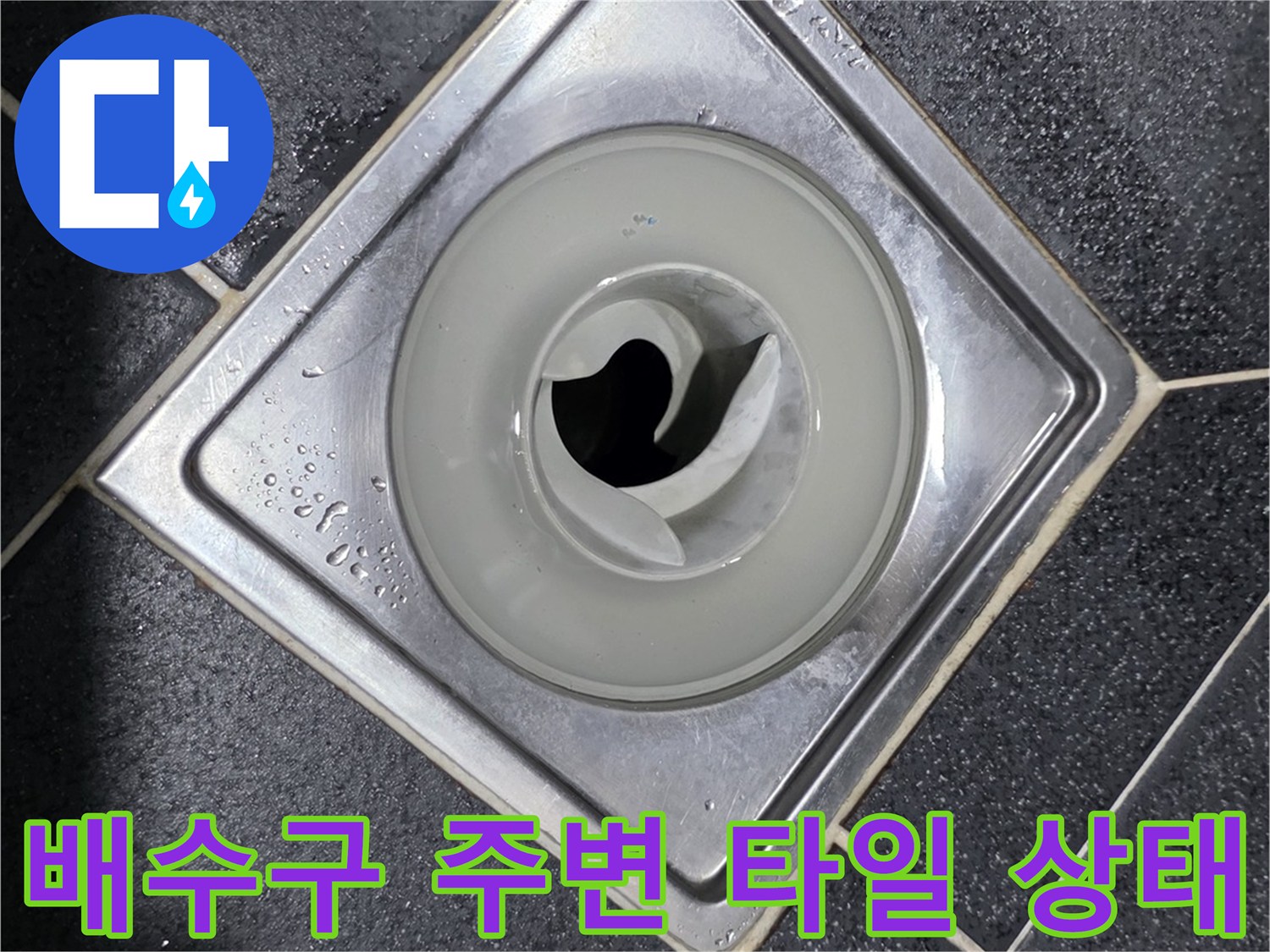 어두운 색상의 타일과 - 금속 배수구 유가 부근의 사진입니다.