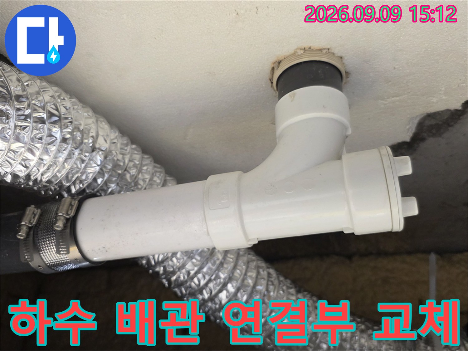 천장 슬래브에 고정된 하수 관로와 은색 보온재가 씌워진 배관의 결합 상태