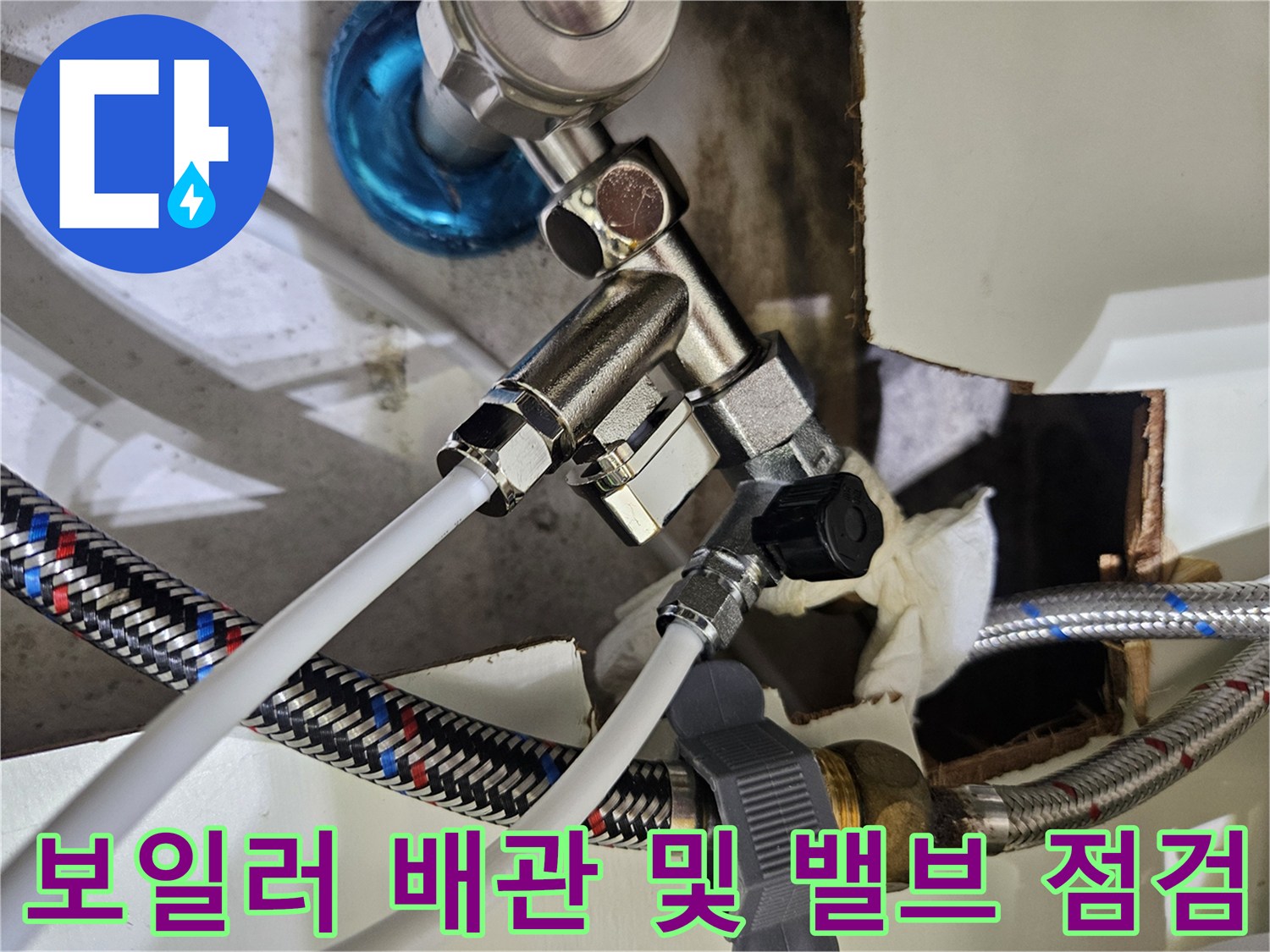 보일러 하단의 금속 밸브와 흰색 배관의 연결 상태 사진