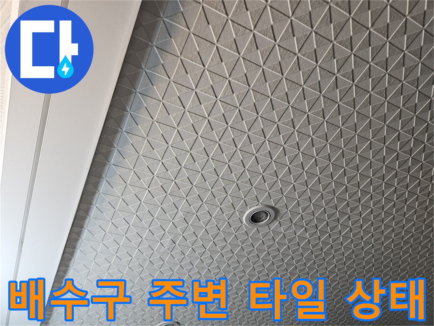 다용도실 바닥의 기하학적 패턴 타일과 배수구 근접 촬영