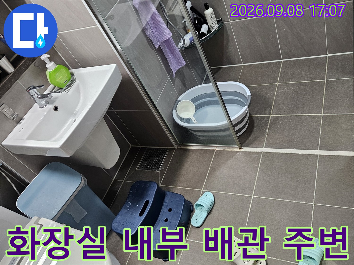 욕실 벽면 타일과 세탁용품이 놓인 공간의 근접 촬영 사진입니다.