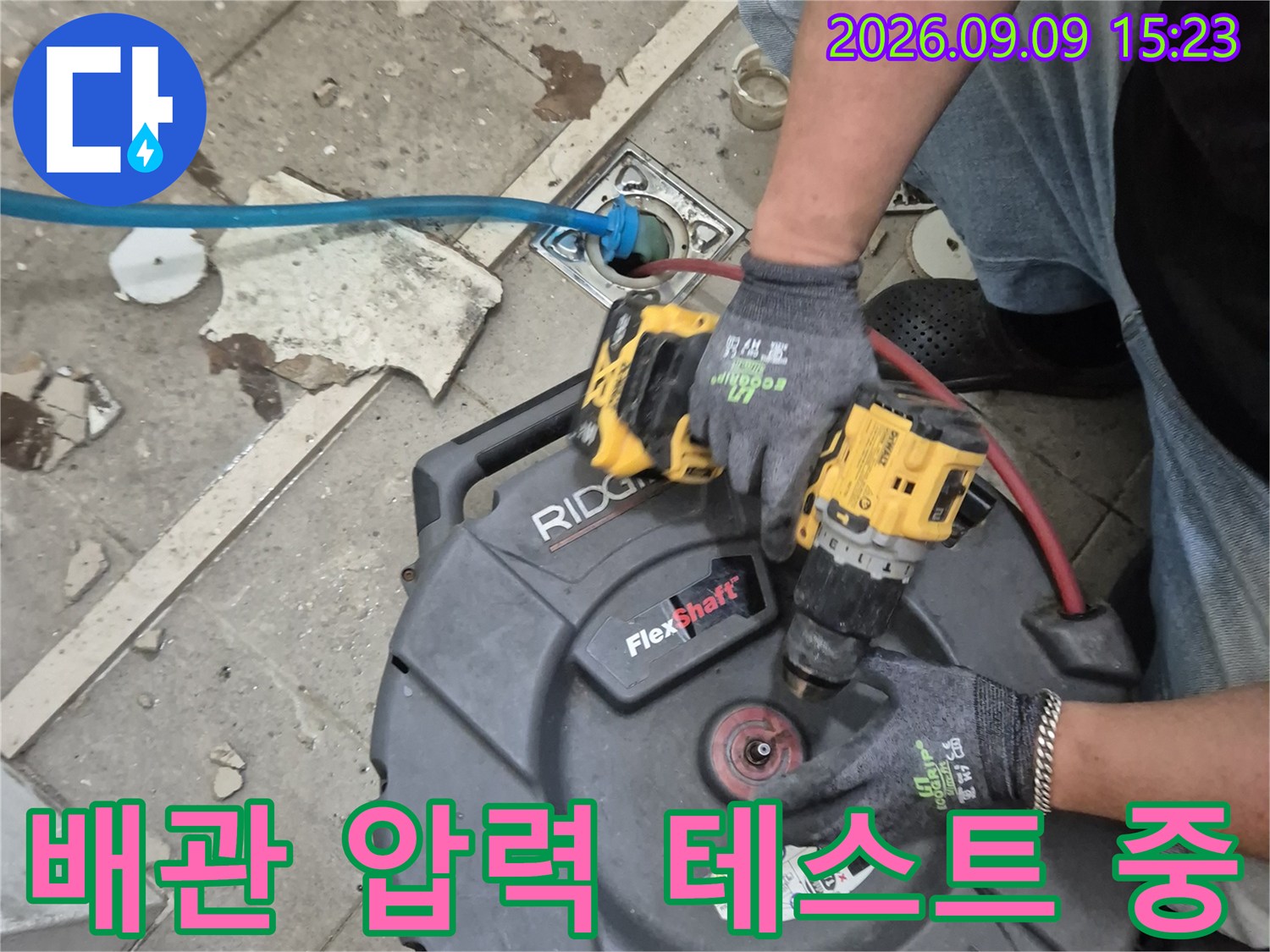 배관에 호스를 연결하여 공압을 가하는 누수 진단 작업 장면입니다.