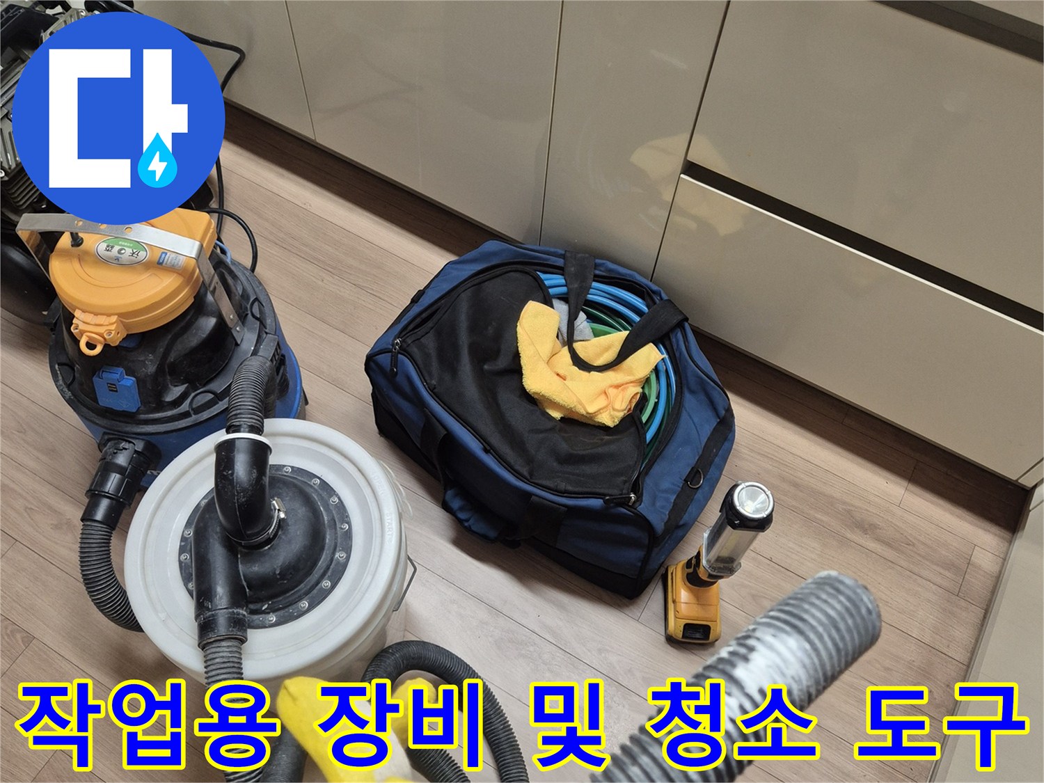 싱크대 밑 바닥에 놓인 누수 탐지 호스와 청소 타월