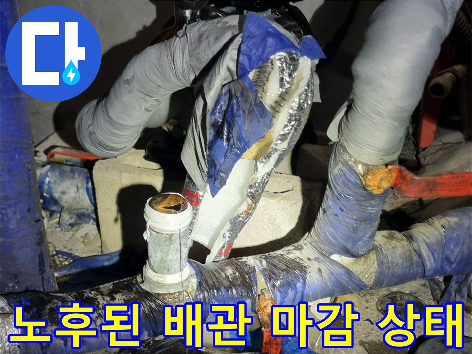 부식된 수도관-보온재와 테이핑으로 덮인 노후 배관의 연결 부위