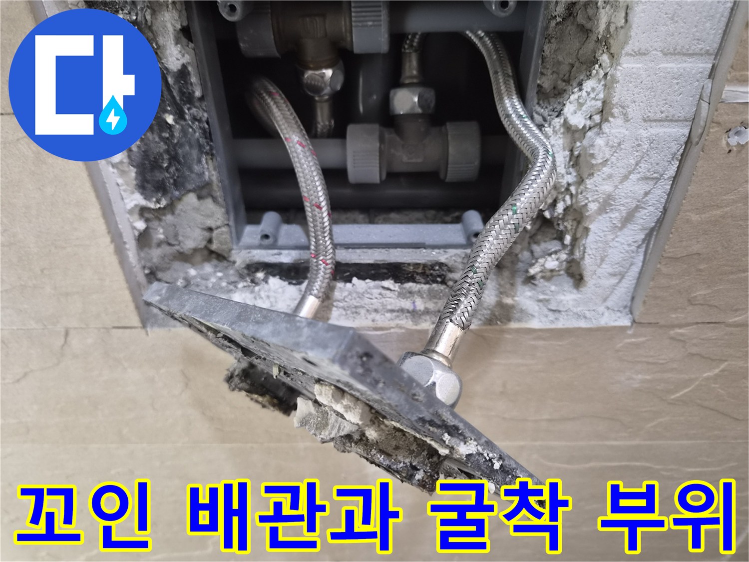 벽면을 파내어 드러난 뒤틀린 수도 호스와 내부 구조물