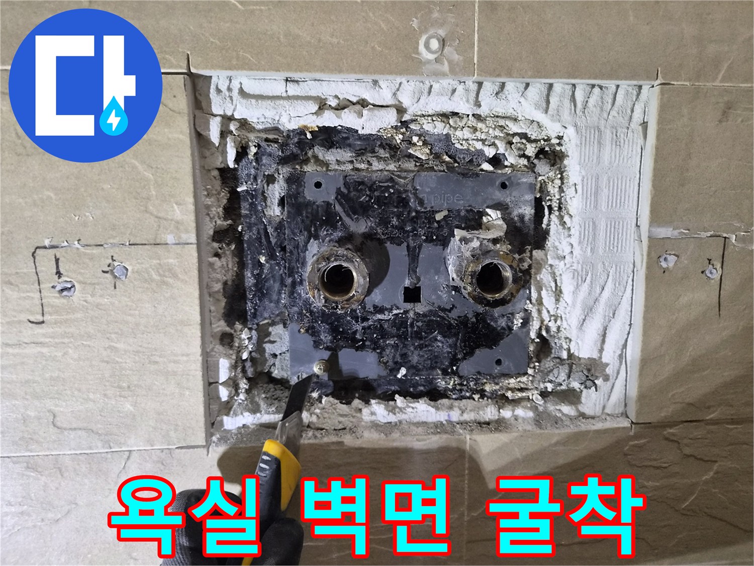타일 안쪽의 배관 연결부를 노출시키기 위해 벽을 파낸 모습입니다.