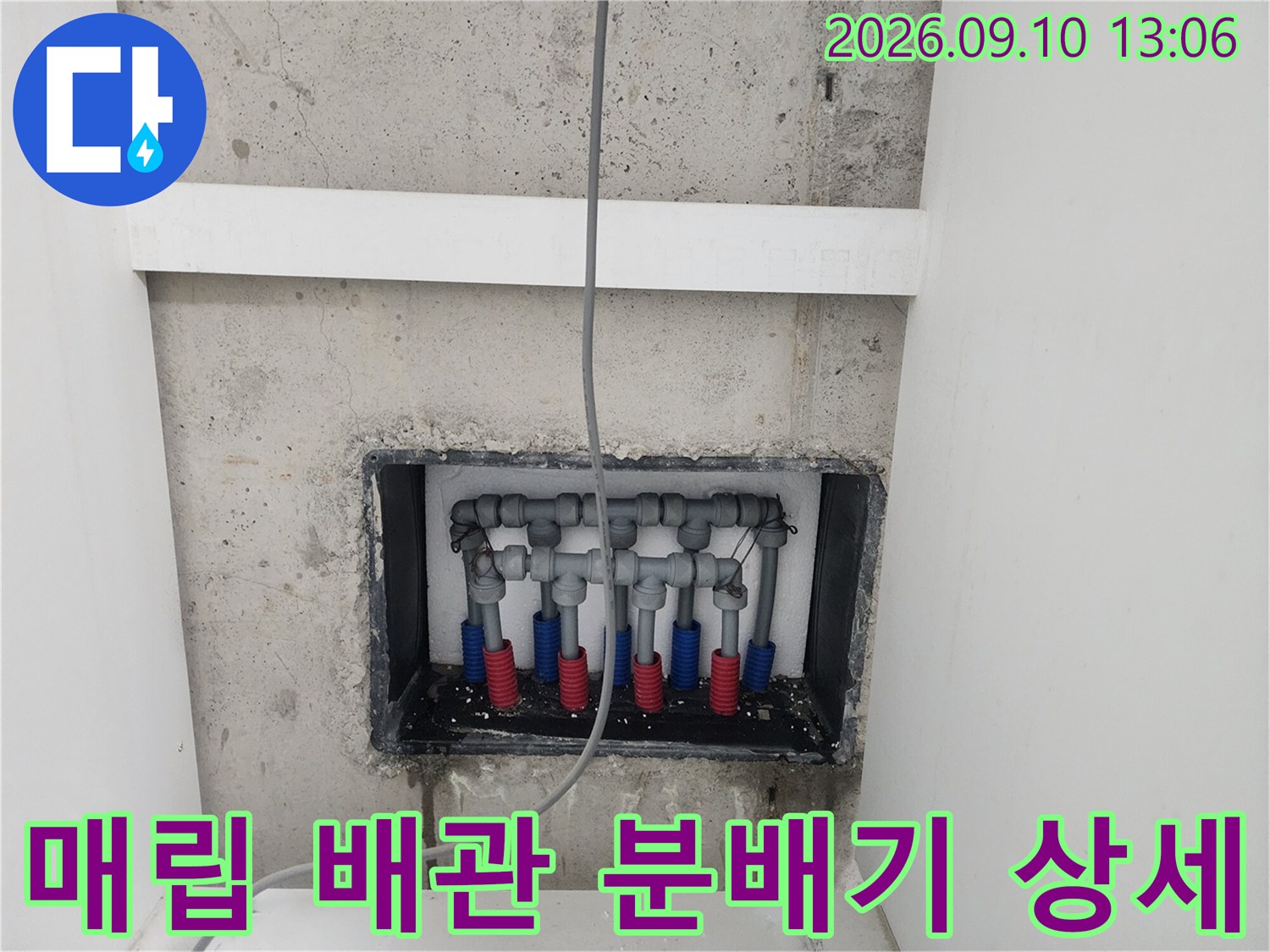 벽면 타공 부위-노출된 수도 분배기와 연결 배관들