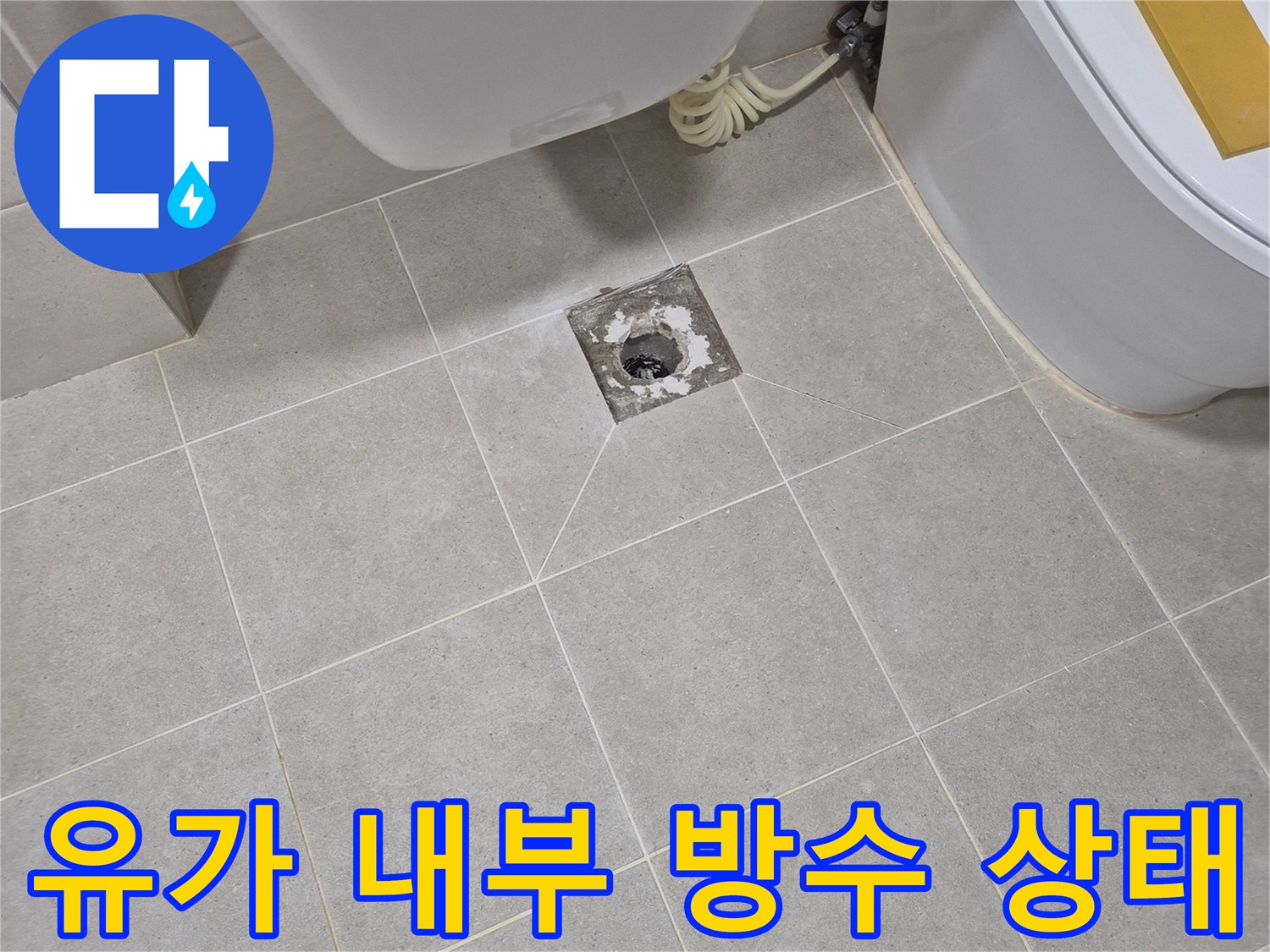 배수구 덮개 아래 드러난 하수관 및 주변 타일 마감