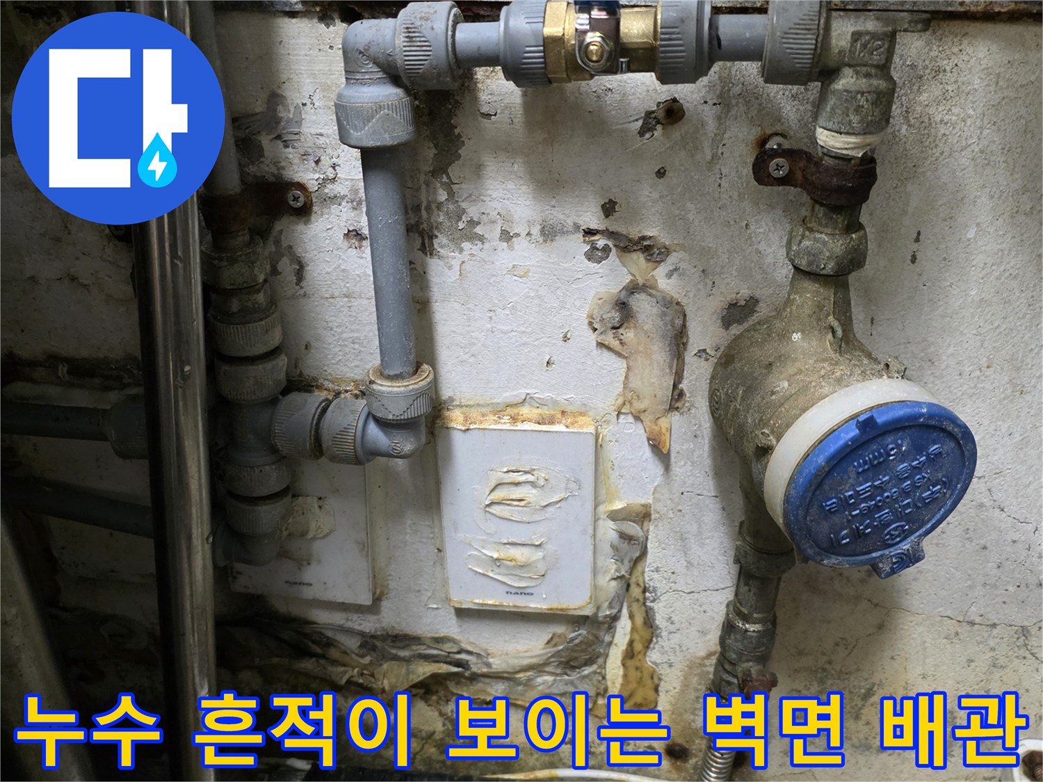 습기로 얼룩진 벽면과 노후된 수도 계량기 연결 부위의 모습