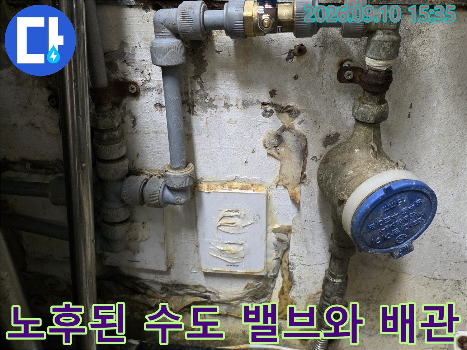 파란색 캡이 씌워진 수도 계량기와 연결된 금속 배관입니다.