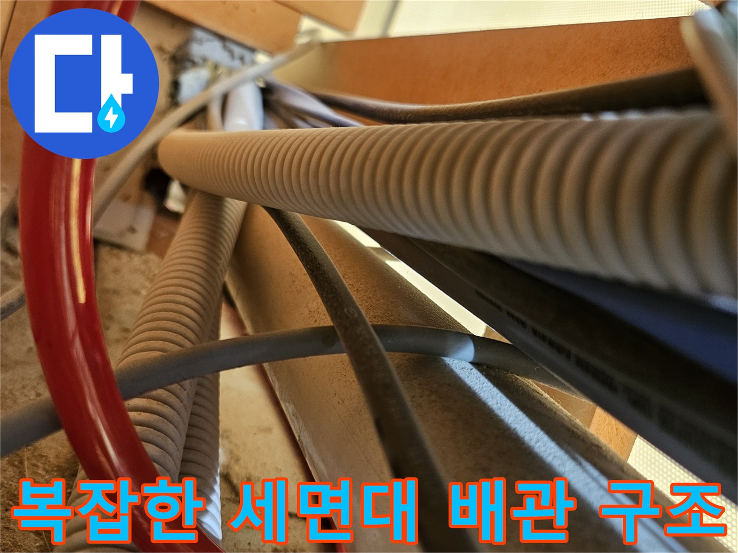 세면대 밑부분-엉켜있는 주름관과 급수 호스 상세 사진